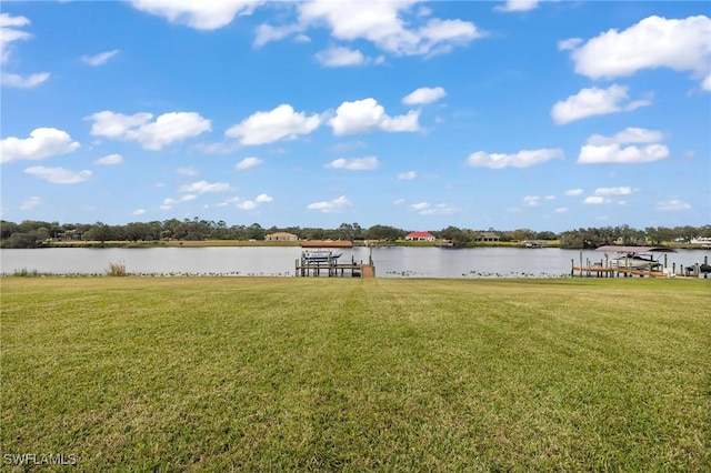 dock area featuring a lawn and a water view