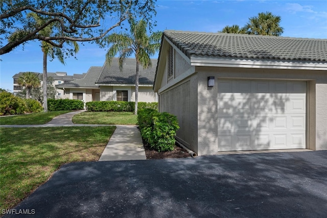 view of side of home with a lawn and a garage