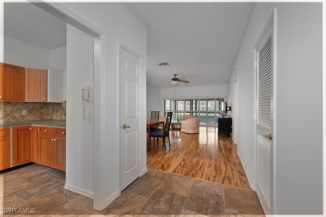 kitchen with tasteful backsplash, ceiling fan, and a textured ceiling