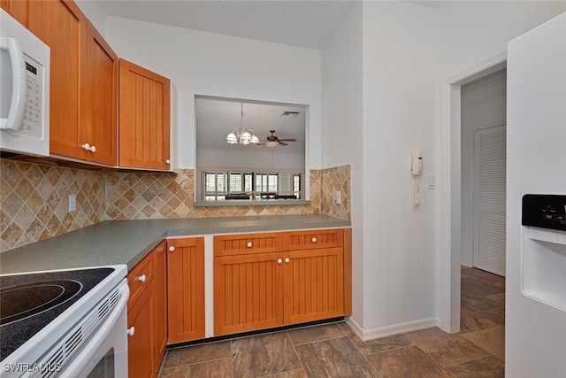 kitchen featuring hanging light fixtures, backsplash, and ceiling fan with notable chandelier