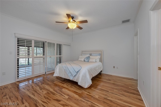 bedroom featuring a textured ceiling, ceiling fan, access to exterior, and light hardwood / wood-style flooring