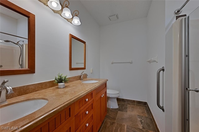 bathroom with a shower with door, toilet, and vanity