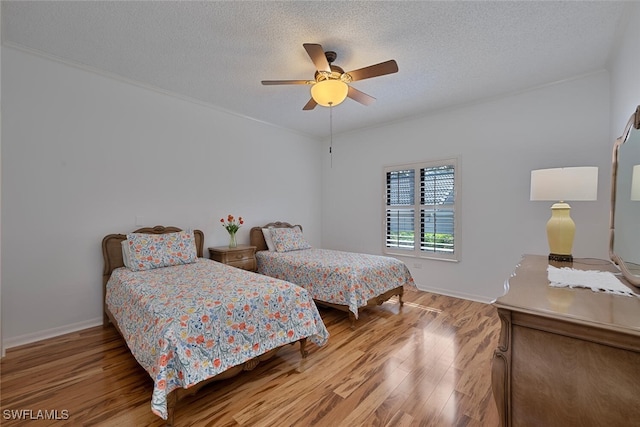 bedroom featuring a textured ceiling, ceiling fan, and hardwood / wood-style floors