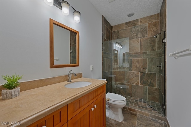 bathroom featuring a shower with shower door, a textured ceiling, toilet, and vanity