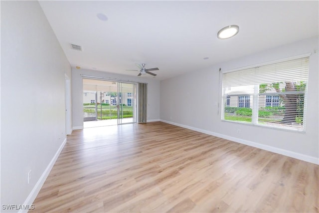 empty room with ceiling fan, plenty of natural light, and light hardwood / wood-style floors