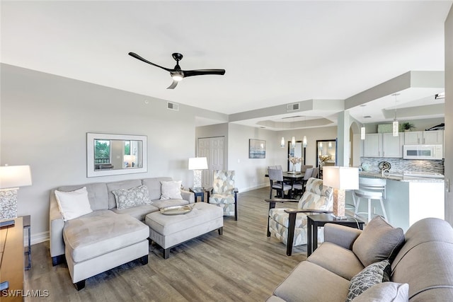 living room with ceiling fan and light wood-type flooring