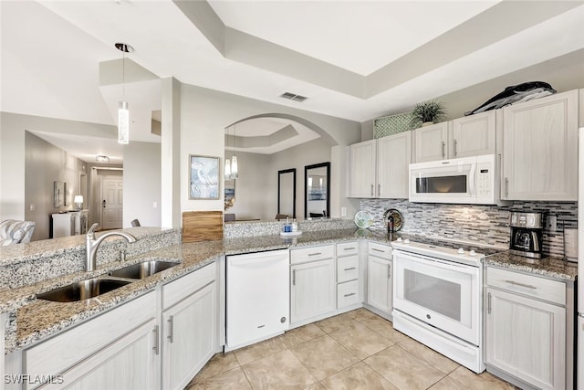 kitchen with sink, white appliances, white cabinets, and a raised ceiling