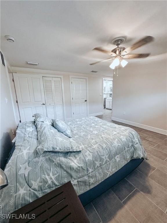 bedroom featuring visible vents, wood finished floors, a ceiling fan, and baseboards