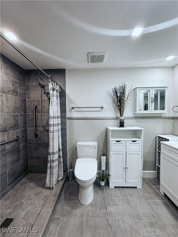 bathroom featuring vanity, toilet, and a shower with shower curtain