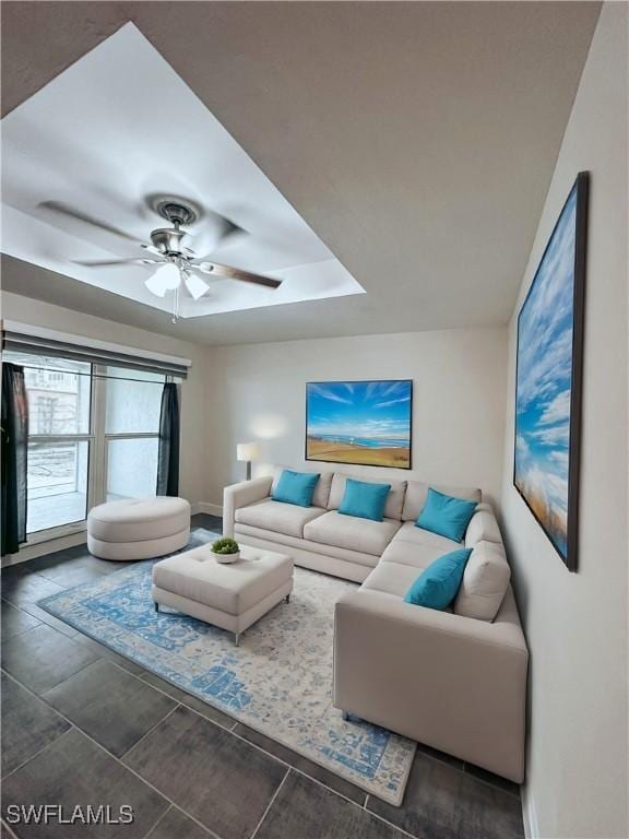 living room featuring baseboards and a ceiling fan