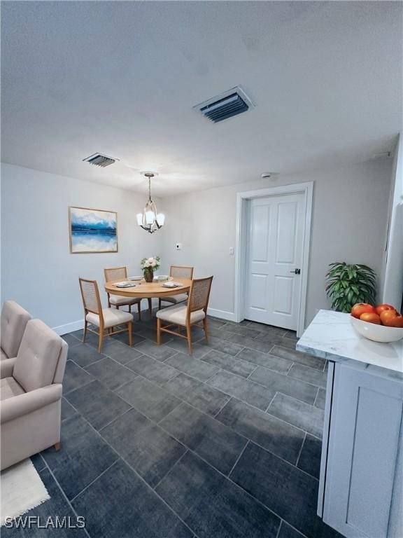 dining space with baseboards, visible vents, and a notable chandelier