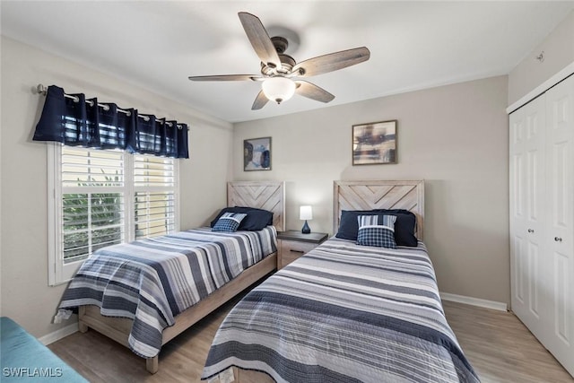 15495 Cedarwood Ln Unit 103, Naples, FL 34110 - bedroom with a closet, baseboards, wood finished floors, and ceiling fan
