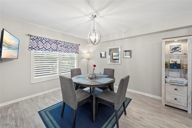 dining area with light wood-type flooring and a chandelier