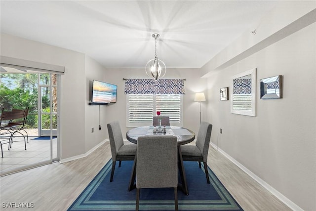 dining space with plenty of natural light, an inviting chandelier, and hardwood / wood-style flooring