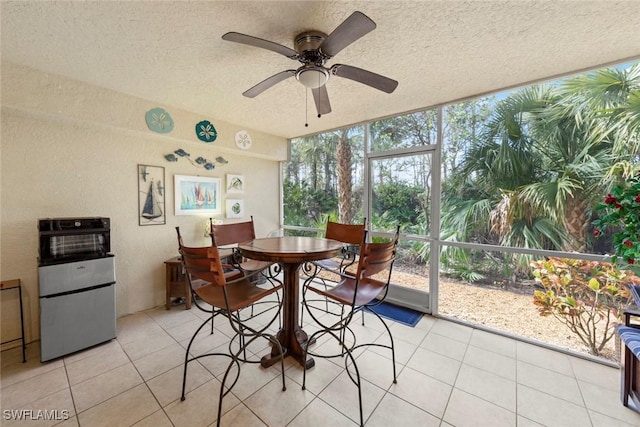 dining room featuring ceiling fan, a textured ceiling, light tile patterned floors, and expansive windows