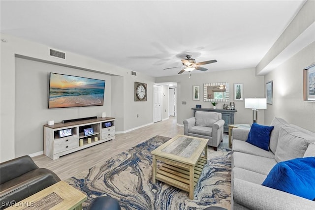 living room featuring light hardwood / wood-style floors and ceiling fan