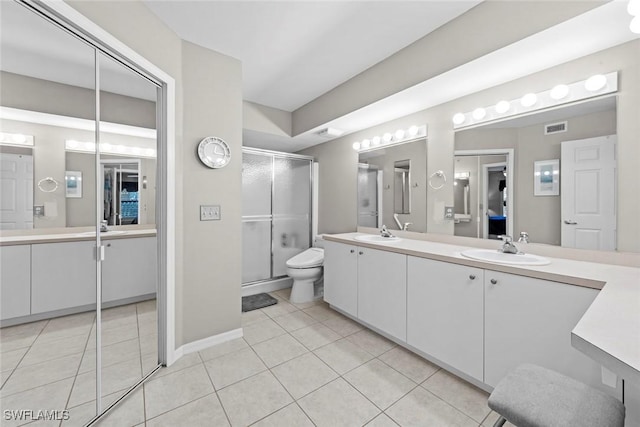 bathroom with vanity, toilet, tile patterned floors, and walk in shower