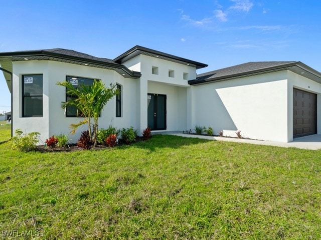 back of house with a garage and a yard