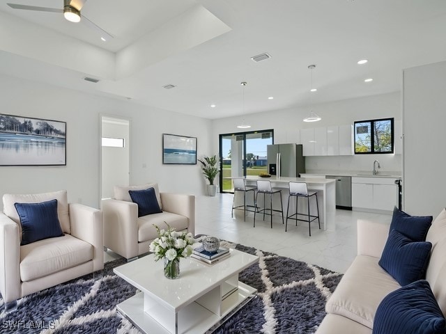 living room with ceiling fan and sink