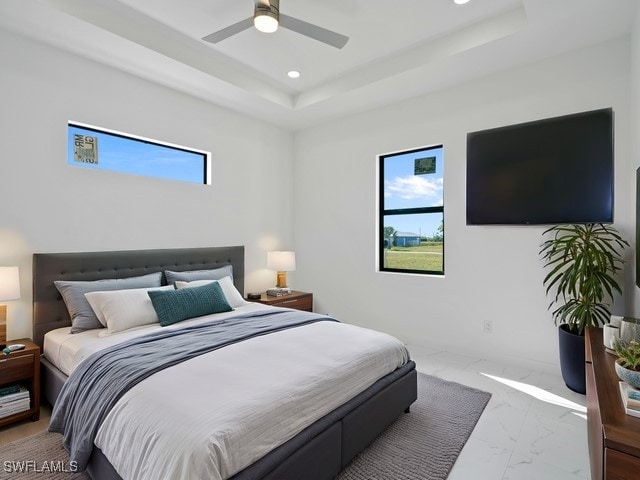 bedroom with ceiling fan and a raised ceiling