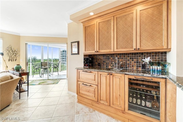 bar with wine cooler, dark stone countertops, sink, light tile patterned floors, and crown molding