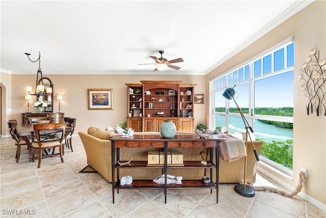 living room featuring ceiling fan with notable chandelier, ornamental molding, a water view, and plenty of natural light