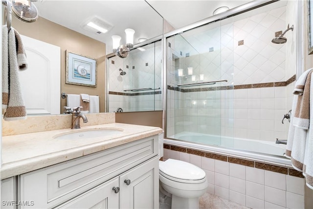 full bathroom with combined bath / shower with glass door, vanity, and toilet