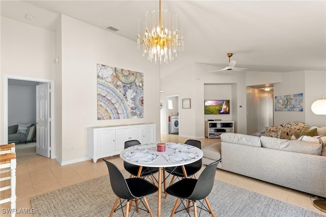 tiled dining space featuring washer / clothes dryer, lofted ceiling, and ceiling fan with notable chandelier