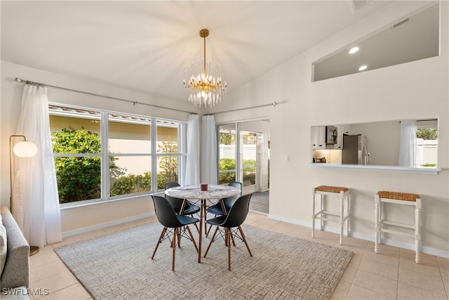 tiled dining room with an inviting chandelier and vaulted ceiling