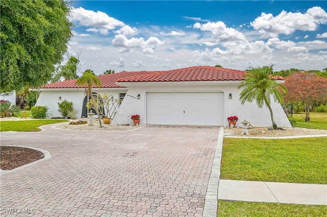 mediterranean / spanish-style home with a garage and a front yard