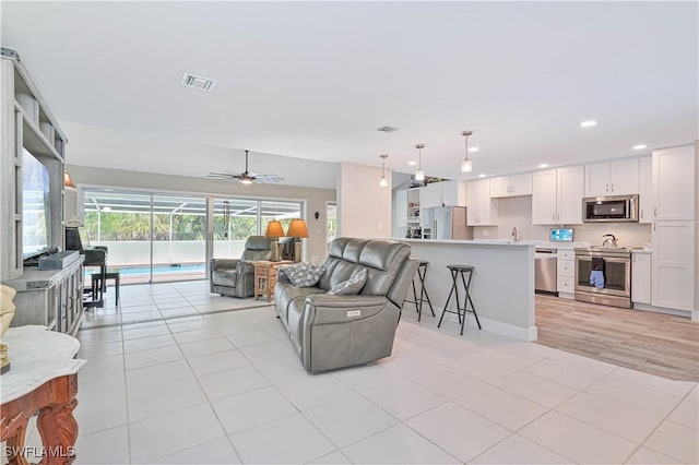 tiled living room with ceiling fan