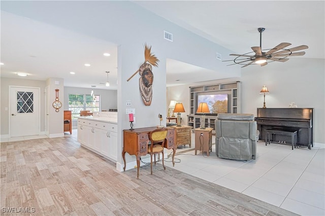 kitchen featuring white cabinets, light hardwood / wood-style floors, hanging light fixtures, kitchen peninsula, and ceiling fan