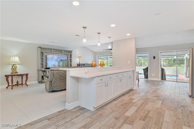 kitchen with white cabinets, hanging light fixtures, light wood-type flooring, ceiling fan, and high end fridge