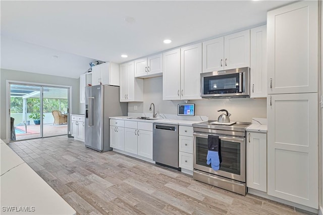 kitchen with white cabinets, appliances with stainless steel finishes, and sink