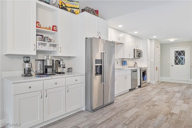 kitchen featuring sink, white cabinets, light hardwood / wood-style floors, and stainless steel appliances