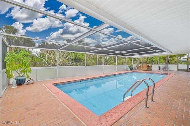 view of swimming pool with a patio area and a lanai