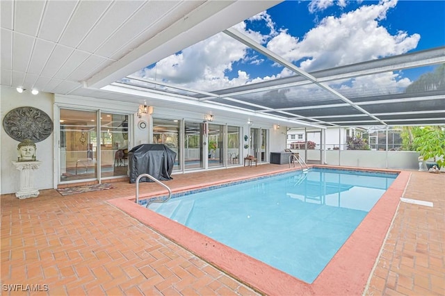 view of pool featuring glass enclosure, a patio, and grilling area