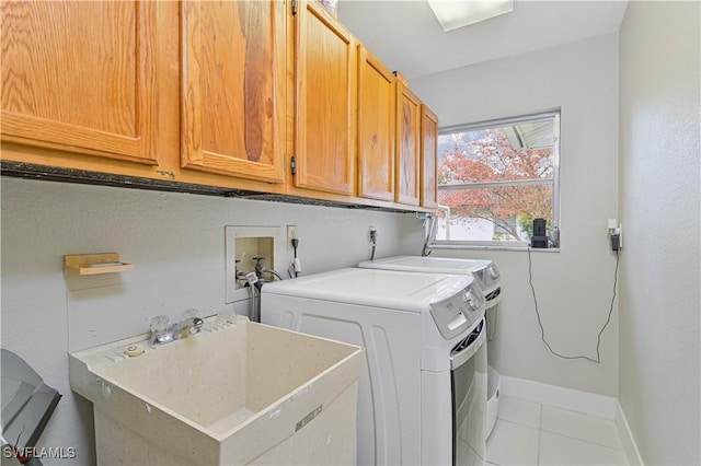 laundry area featuring sink, cabinets, washer and dryer, and light tile patterned floors