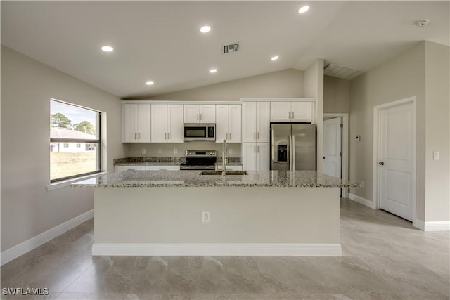 kitchen featuring sink, light stone counters, stainless steel appliances, and white cabinetry