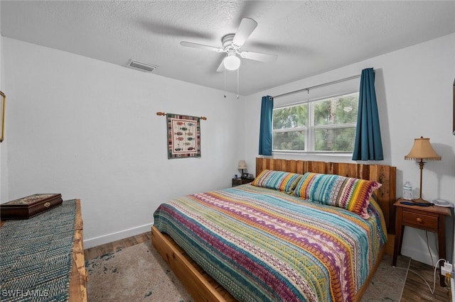 bedroom featuring a textured ceiling, ceiling fan, and wood-type flooring