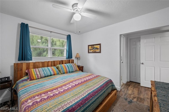 bedroom featuring a textured ceiling, ceiling fan, and dark hardwood / wood-style flooring