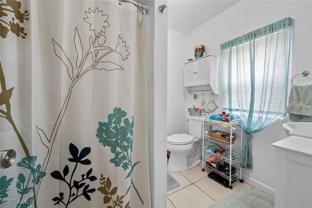 bathroom with toilet, vanity, and tile patterned floors