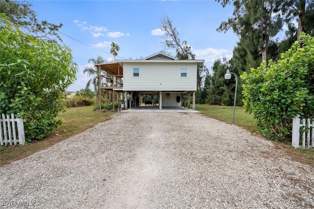 rear view of property with a carport and a yard