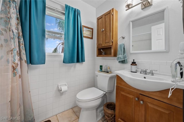 bathroom with toilet, vanity, tile walls, and tile patterned floors