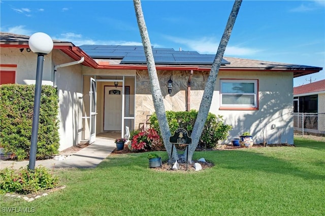 view of front facade featuring a front yard and solar panels