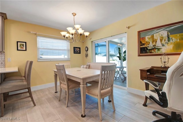 dining room with light wood-type flooring and a notable chandelier