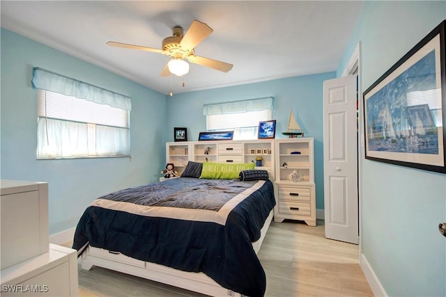 bedroom featuring ceiling fan, a closet, and light wood-type flooring