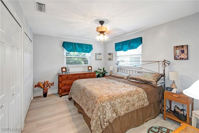 bedroom featuring ceiling fan, light hardwood / wood-style flooring, and multiple windows