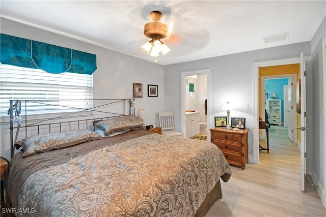 bedroom featuring ceiling fan, light hardwood / wood-style flooring, and ensuite bath