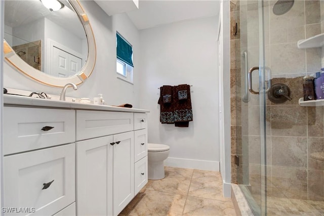 bathroom featuring toilet, vanity, and a shower with door